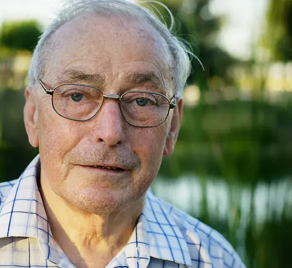 Real GlycoHarmony customer review portrait of an elderly man smiling outdoors, representing healthy longevity and vitality.