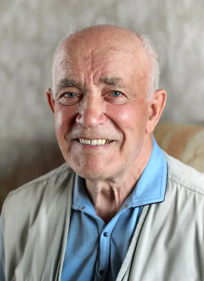 Portrait of a smiling senior citizen man with white hair, expressing happiness and active physical health.